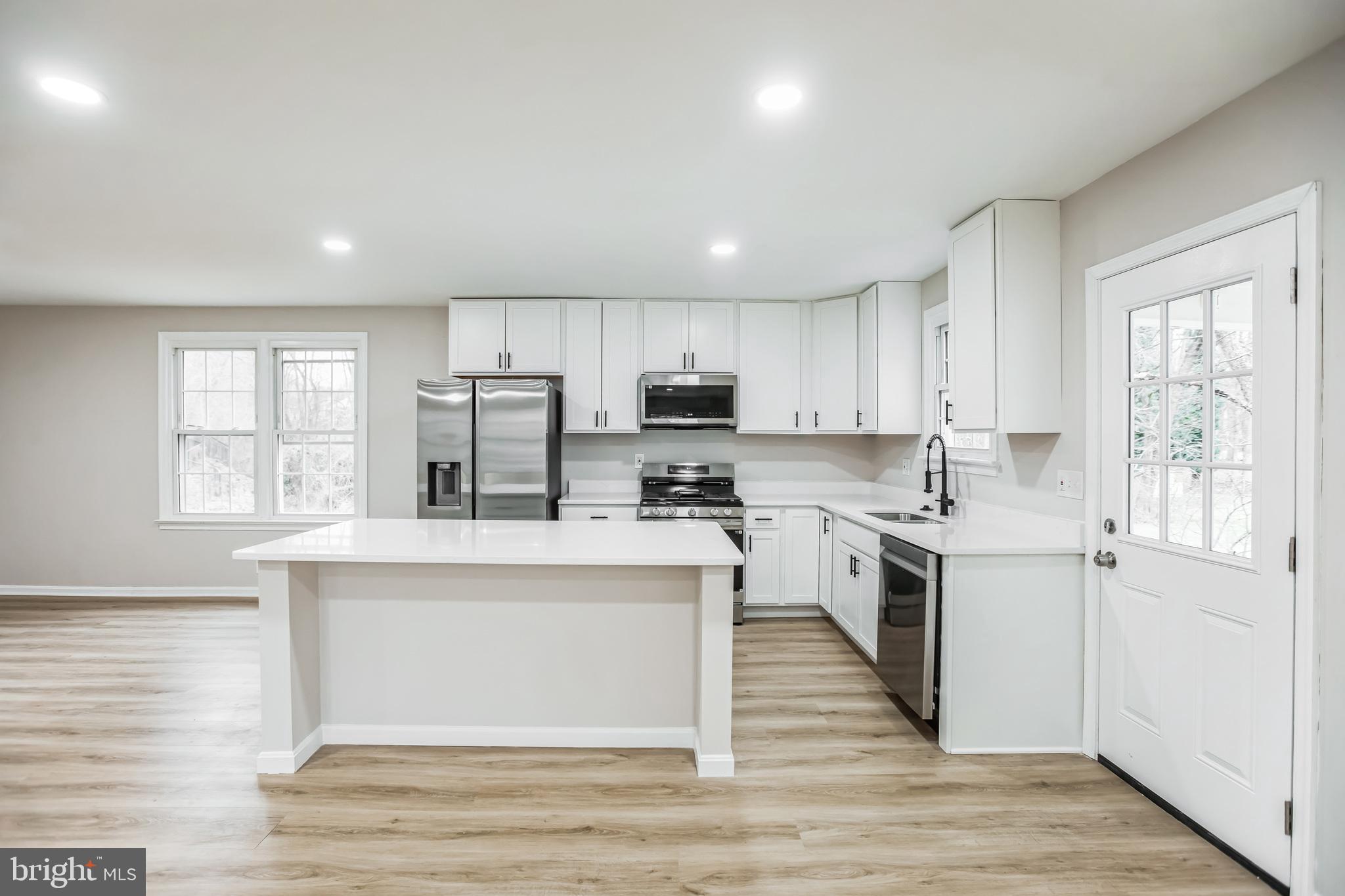 5201 Roblee Drive Upper Marlboro, MD 20772 - Photo 7 of 27 a kitchen with stainless steel appliances granite countertop a stove top oven a refrigerator a sink and dishwasher with wooden floor