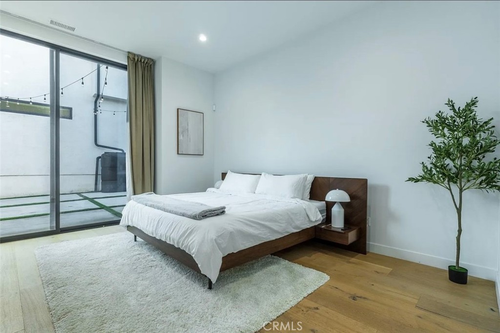 12136 Clarkson Road Los Angeles, CA 90064 - Photo 12 of 23 a bedroom with a bed and a potted plant