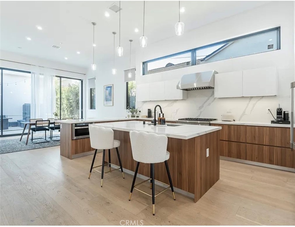 12136 Clarkson Road Los Angeles, CA 90064 - Photo 2 of 23 a kitchen with a dining table chairs cabinets and stainless steel appliances