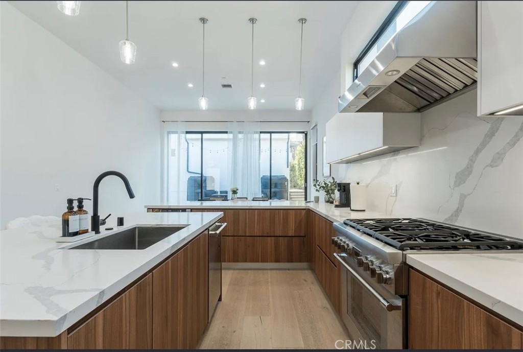 12136 Clarkson Road Los Angeles, CA 90064 - Photo 8 of 23 a kitchen with stainless steel appliances a sink a stove and cabinets