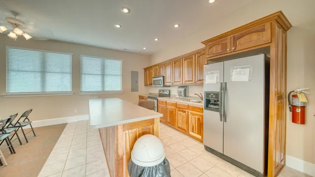 a kitchen with stainless steel appliances granite countertop a refrigerator a stove and a sink with granite countertops