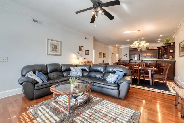 a living room with furniture kitchen view and a chandelier