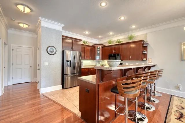a kitchen with stainless steel appliances kitchen island granite countertop a refrigerator and a stove top oven