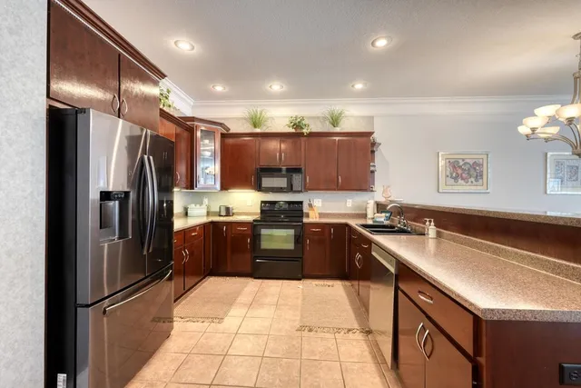 a kitchen with stainless steel appliances granite countertop a sink refrigerator and cabinets
