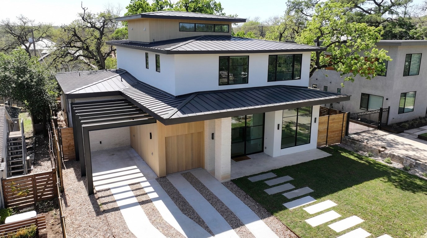 View of front of home featuring a standing seam roof, a garage, a gate, and driveway (carport to be built)