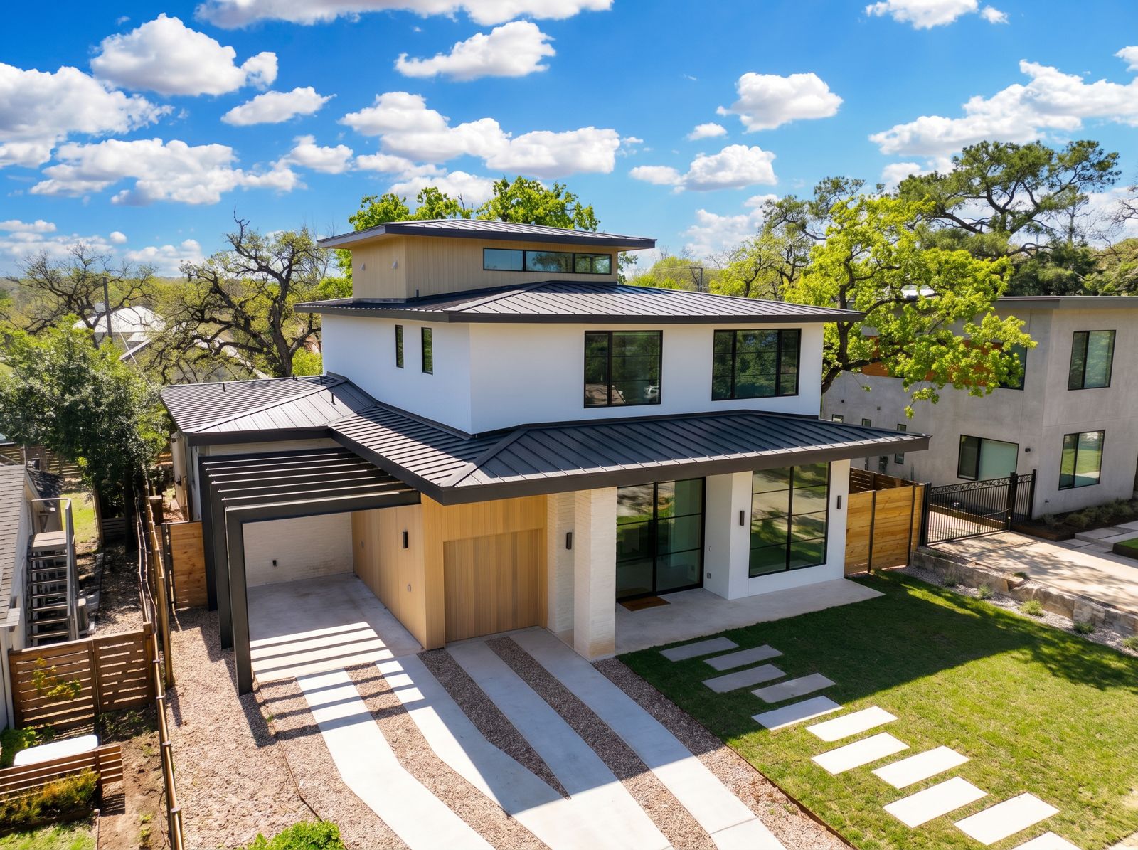 3411 Bridle Path Austin, TX 78703 - Photo 2 of 40 Contemporary residence featuring a white stucco exterior, dark metal roof, and wood-finish accents