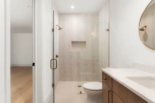 a bathroom with a granite countertop sink a toilet and shower