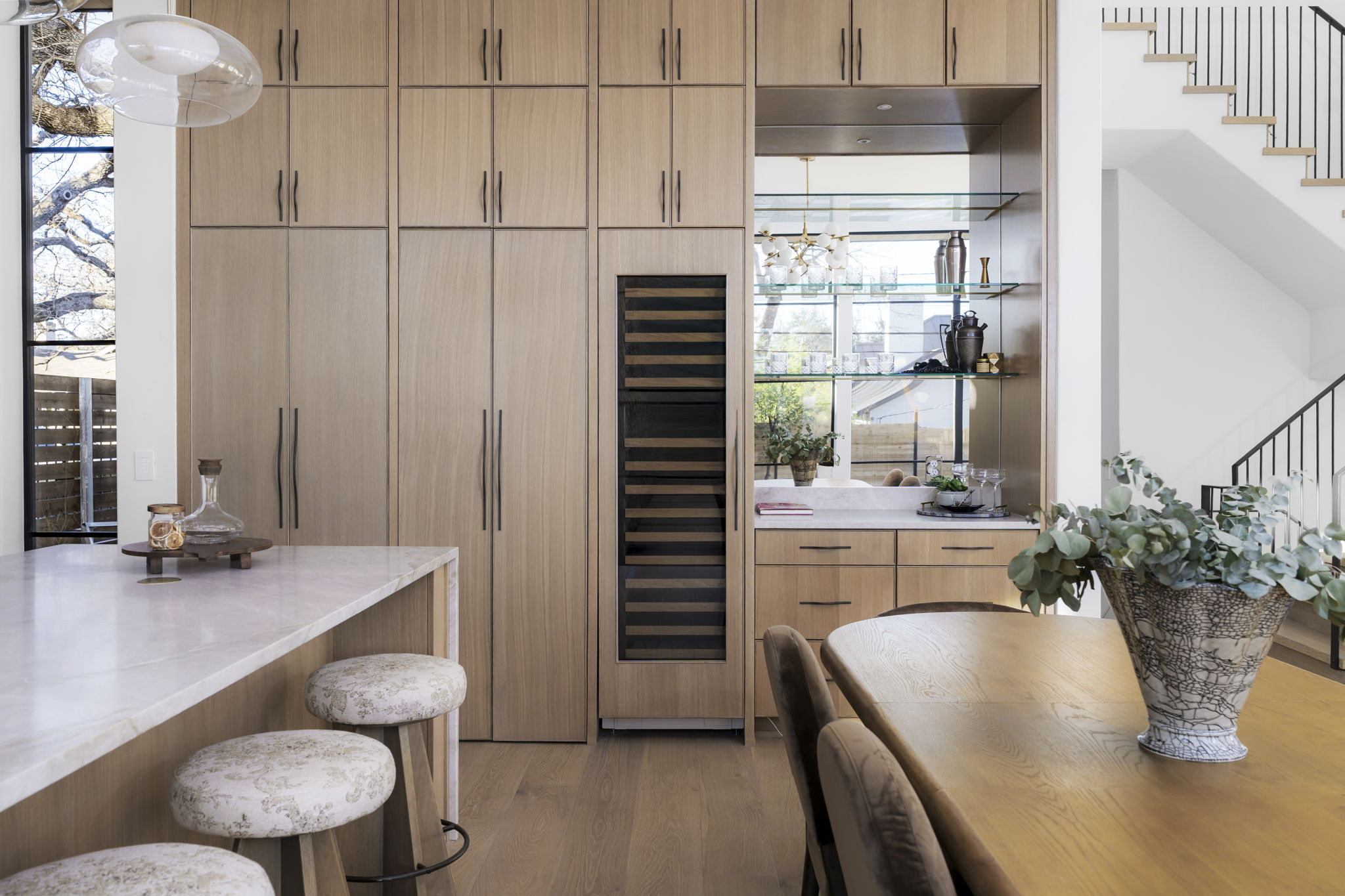 3411 Bridle Path Austin, TX 78703 - Photo 9 of 40 Indoor wet bar featuring beverage cooler, light stone countertops, light wood-type flooring, modern cabinets, and plenty of natural light