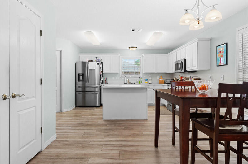 186 Shipwreck Road Santa Rosa Beach, FL 32459 - Photo 25 of 37 a kitchen with stainless steel appliances granite countertop a dining table chairs and closet
