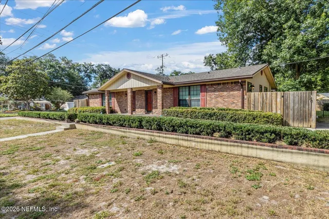 a front view of a house with a yard and potted plants