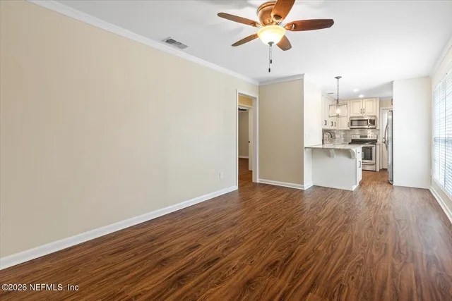 a view of a kitchen with wooden floor and a ceiling fan