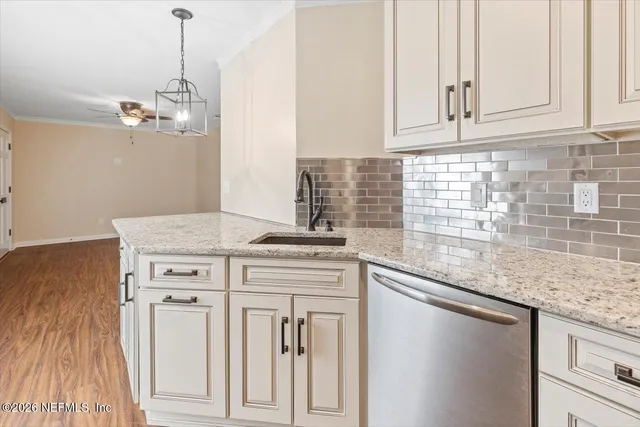 a kitchen with stainless steel appliances granite countertop a sink and dishwasher with white cabinets