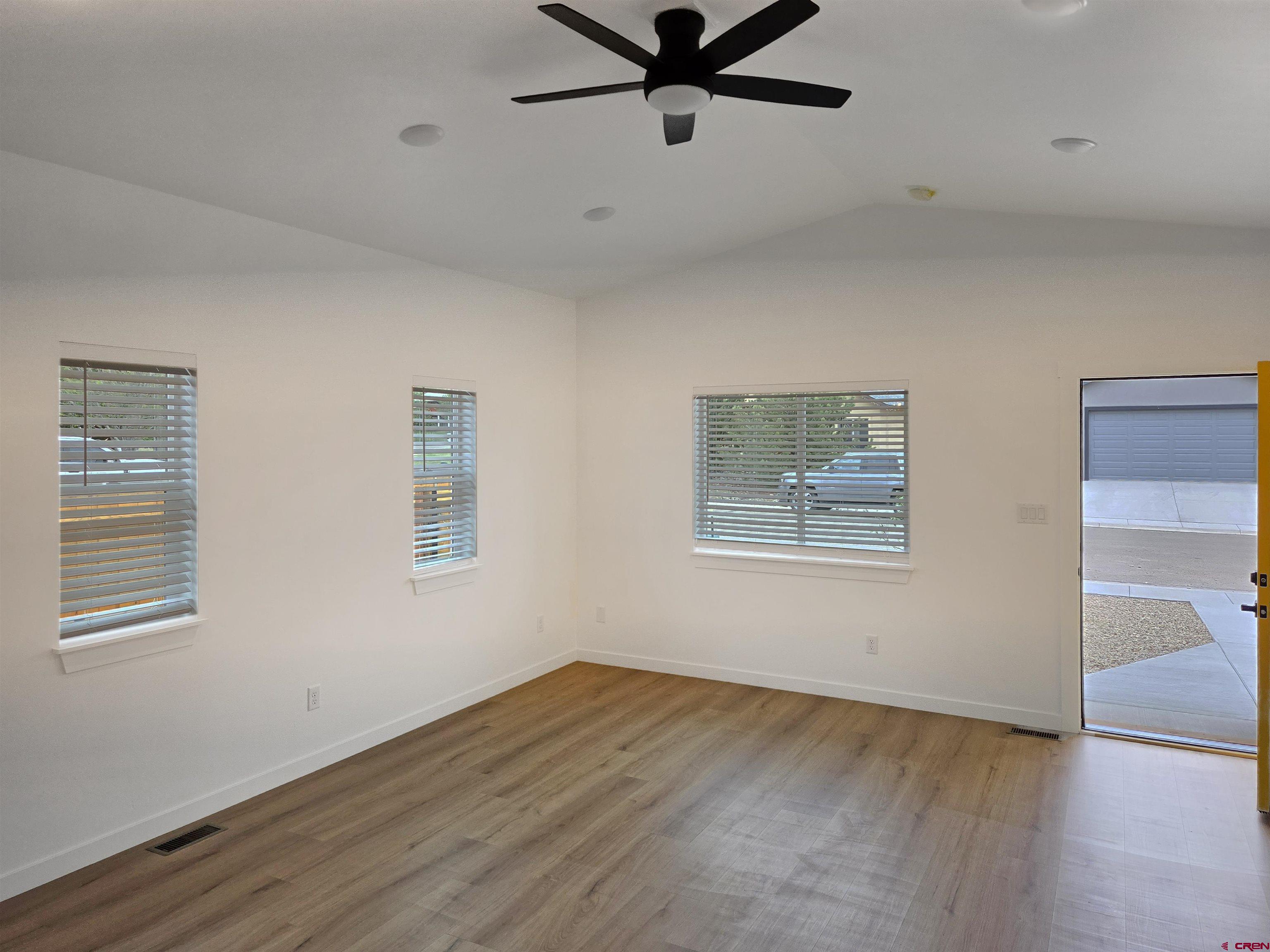 1456 Acoma Street Cortez, CO 81321 - Photo 6 of 26 a view of an empty room with wooden floor and a window