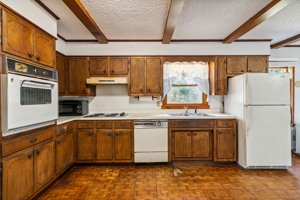 855 Lickskillet Road Epworth, GA 30541 - Photo 10 of 35 a kitchen with stainless steel appliances granite countertop a refrigerator a sink dishwasher a stove and white countertops with wooden floor