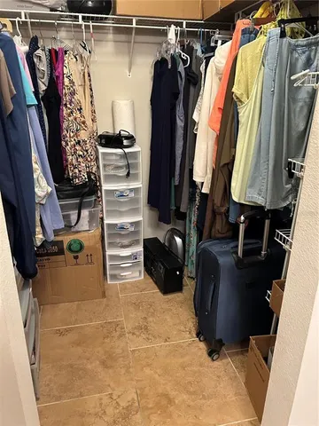 a view of walk in closet with clothes and shoes