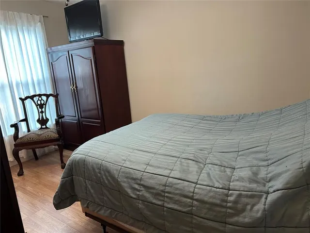 a bedroom with a bed chair and mirror