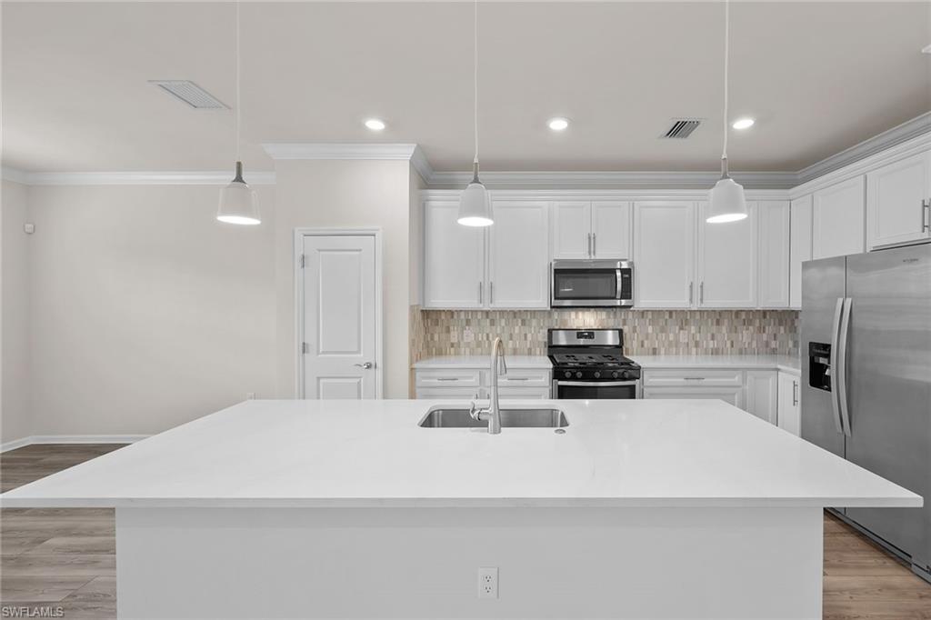 2236 Yellowfin Circle Naples, FL 34114 - Photo 12 of 39 a kitchen with a refrigerator and a stove top oven