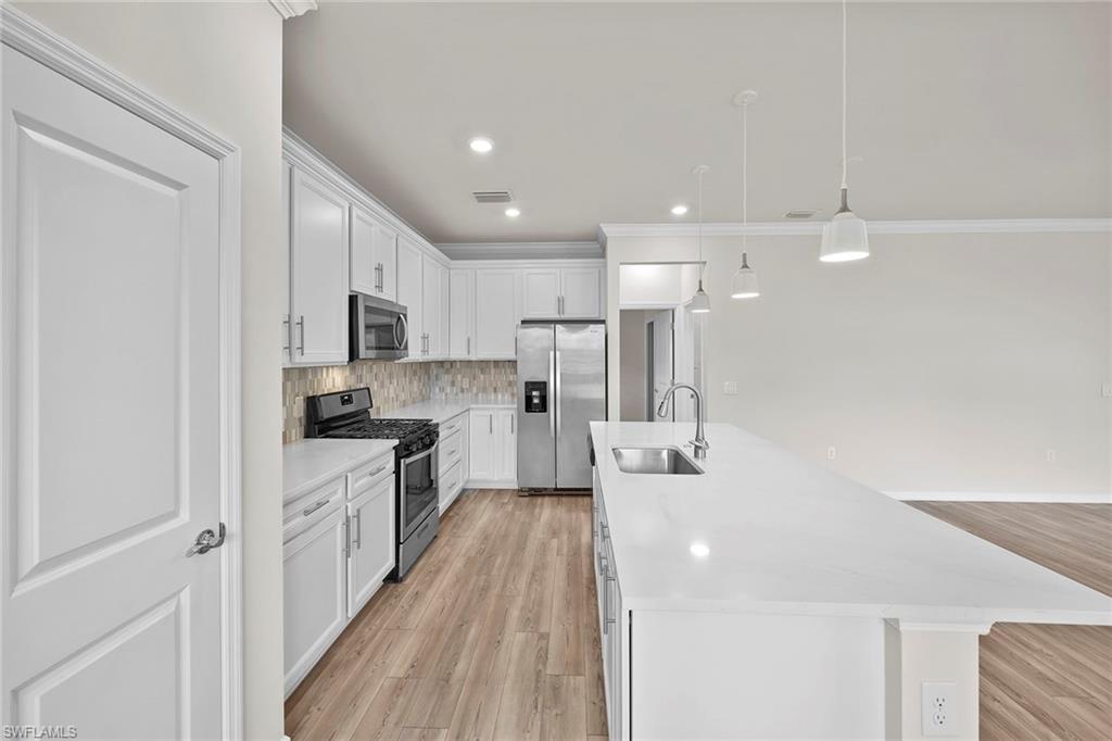 2236 Yellowfin Circle Naples, FL 34114 - Photo 14 of 39 a large white kitchen with stainless steel appliances