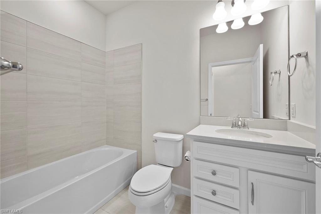 2236 Yellowfin Circle Naples, FL 34114 - Photo 17 of 39 a bathroom with a sink a toilet a mirror a vanity and bathtub