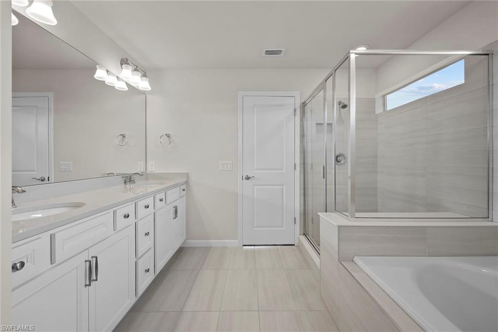 2236 Yellowfin Circle Naples, FL 34114 - Photo 20 of 39 a bathroom with a tub a sink and a mirror