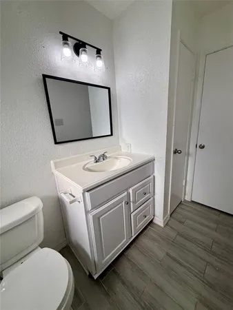 a bathroom with a toilet sink and mirror