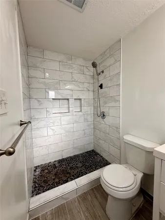 a bathroom with a toilet and a shower