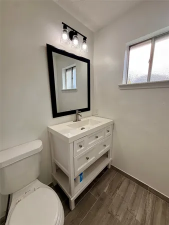 a bathroom with a toilet sink and mirror