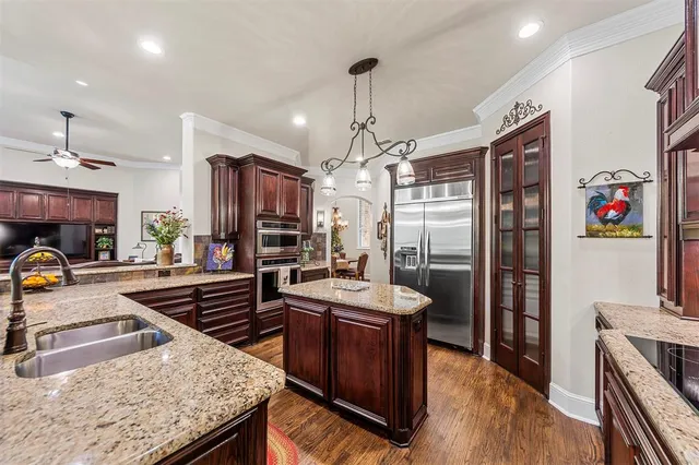 a kitchen with stainless steel appliances granite countertop stove top oven and refrigerator