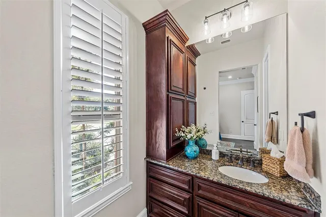 a bathroom with a granite countertop sink and a mirror