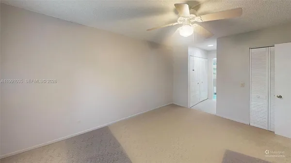 an empty room with a ceiling fan and a window