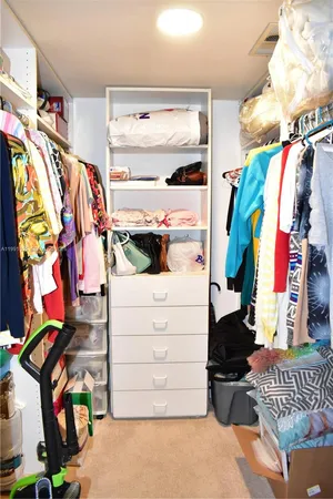 a view of walk in closet with clothes and shoes