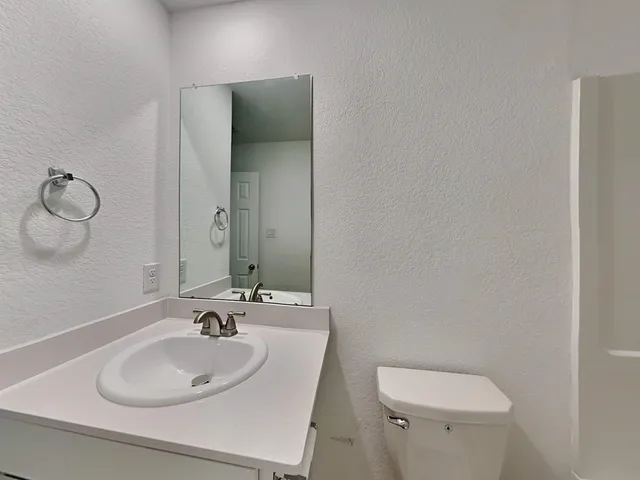 a bathroom with a toilet sink and mirror