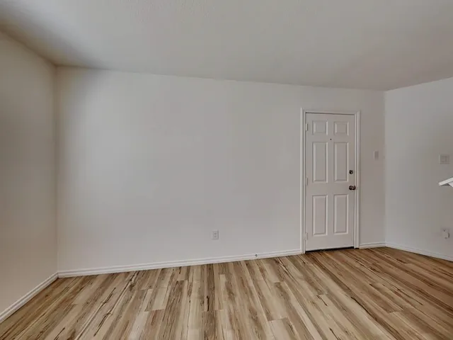 a view of an empty room and wooden floor