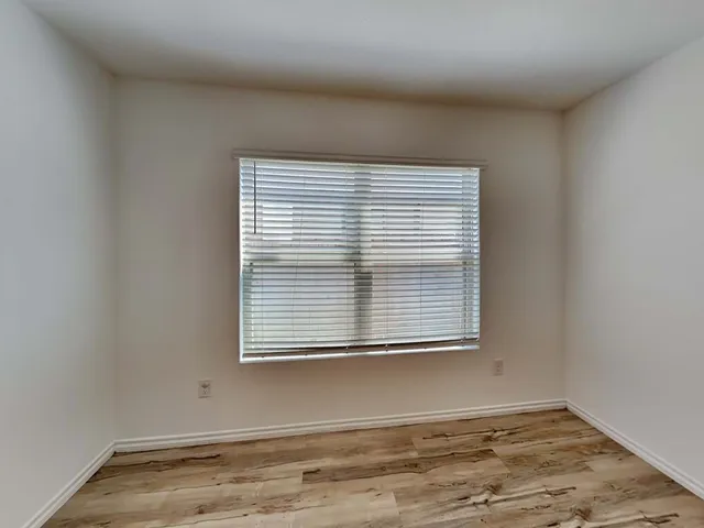 a view of a room with wooden floor and a window
