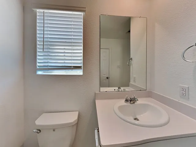 a bathroom with a sink toilet and a mirror