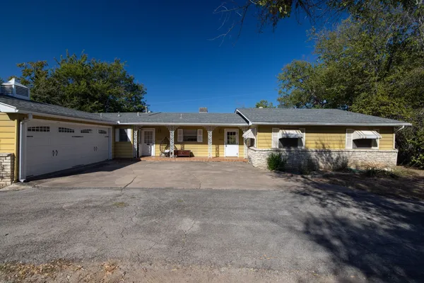 a view of a house with backyard and sitting area