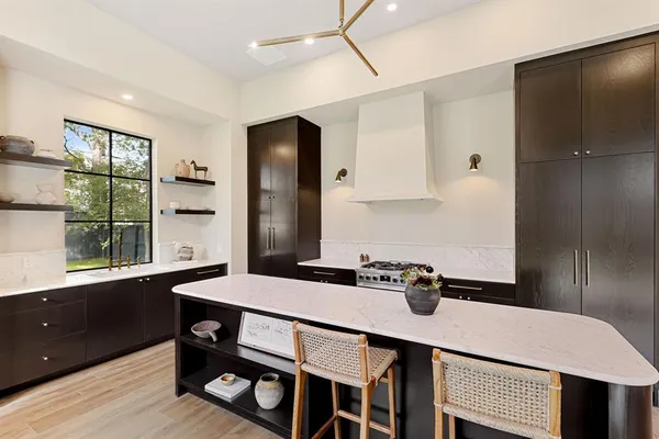 a kitchen with a table chairs a sink dishwasher refrigerator and cabinets
