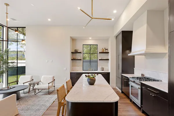 a kitchen with a stove a refrigerator and a dining table