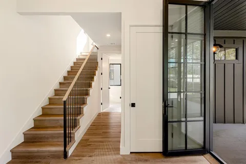 a view of a hallway with wooden floor and entryway