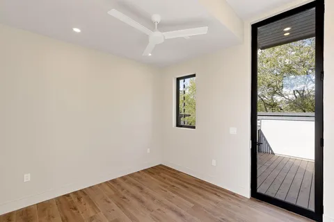 a view of hallway with a large window and wooden floor