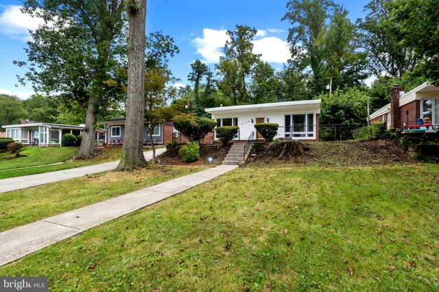 a view of a house with backyard and sitting area