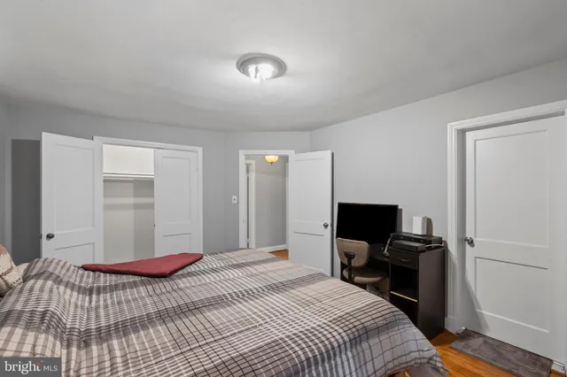 a bedroom with a bed and a flat tv screen on a dresser