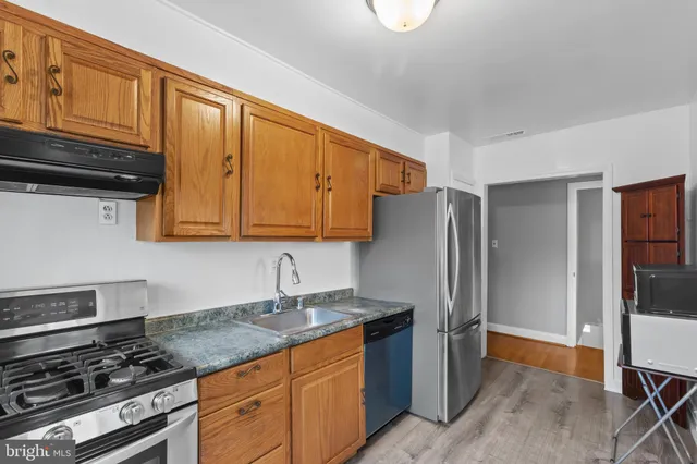 a kitchen with stainless steel appliances granite countertop a refrigerator stove and sink