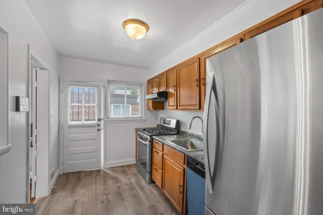 a kitchen with stainless steel appliances granite countertop a stove a sink and a refrigerator