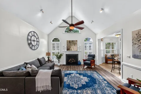 a living room with furniture a fireplace and a chandelier