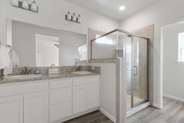 a bathroom with a granite countertop sink mirror and cabinets