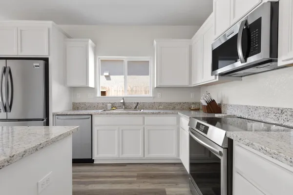 a kitchen with stainless steel appliances granite countertop a sink stove and microwave