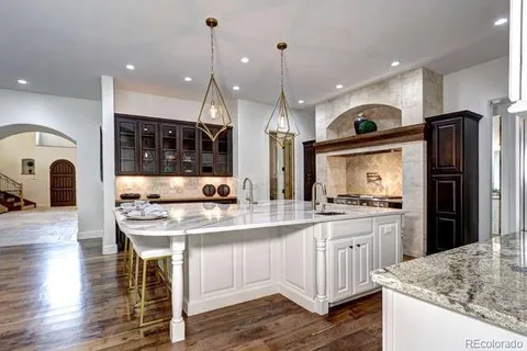a kitchen with kitchen island granite countertop a sink a center island stainless steel appliances and cabinets