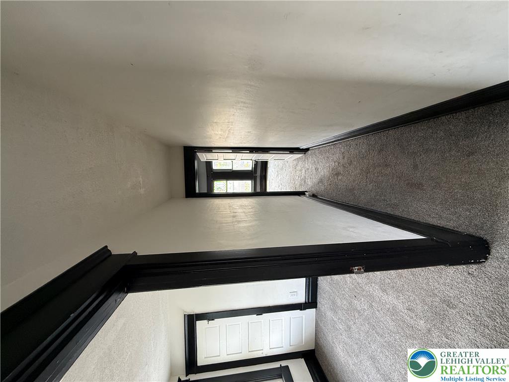 41 West Ridge Street Lansford, PA 18232 - Photo 32 of 40 A well-maintained hallway with neutral carpet and classic dark trim leads to sun-filled spaces.