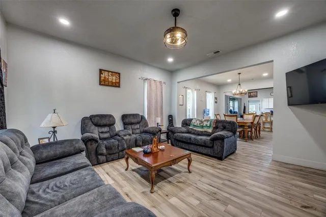 a living room with furniture a flat screen tv and kitchen view